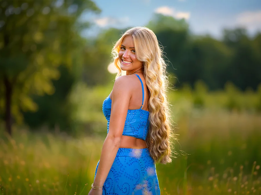 Outdoor senior portrait in a blue dress, photographed by BIZ Photography