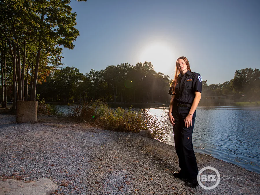 Senior standing beside the water during an outdoor portrait session